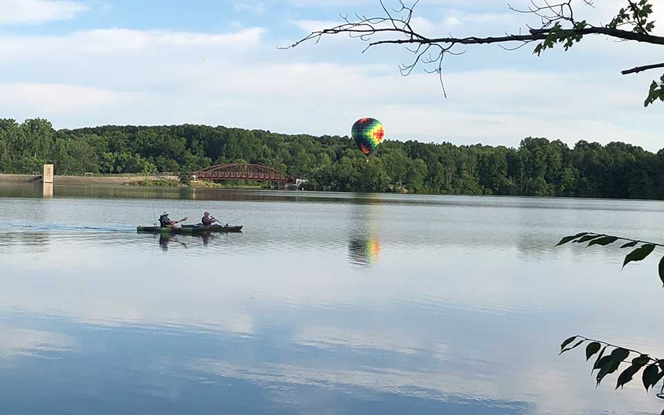 Kayakers on water with bridge in background