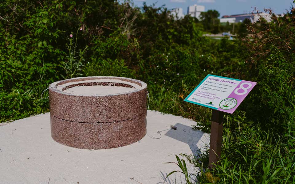 Sand in barrel with rakes attached and sign next to it
